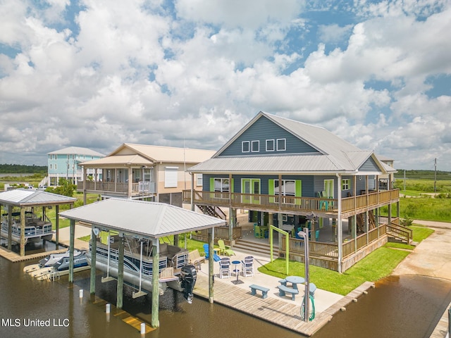 dock area featuring a lawn, a water view, and a balcony