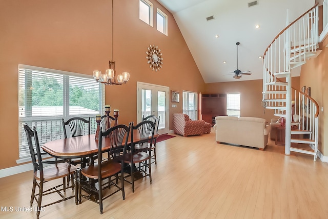 dining room with a healthy amount of sunlight, light hardwood / wood-style flooring, and high vaulted ceiling