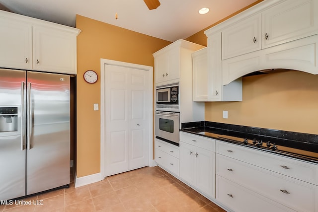 kitchen with ceiling fan, stainless steel appliances, white cabinets, dark stone countertops, and light tile patterned floors