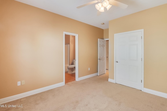 unfurnished bedroom with ensuite bathroom, light colored carpet, and ceiling fan