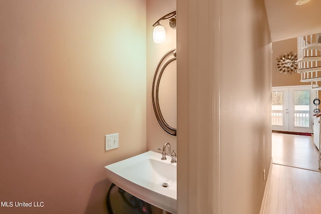 bathroom featuring french doors, hardwood / wood-style flooring, and sink