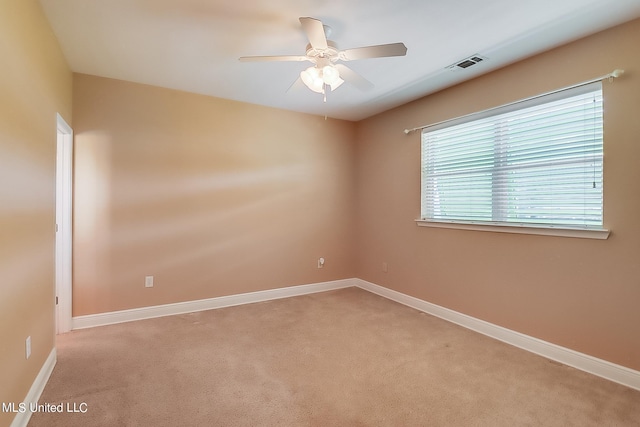 spare room with ceiling fan and light colored carpet