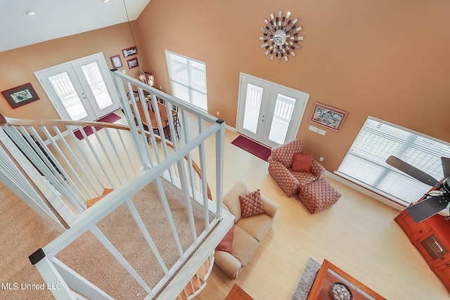 stairway featuring french doors and high vaulted ceiling