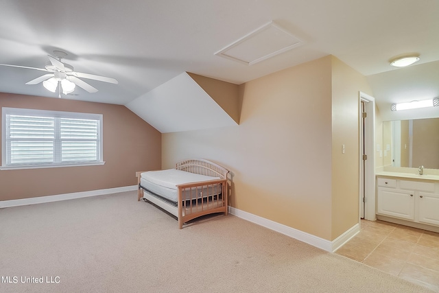 carpeted bedroom featuring sink, vaulted ceiling, ensuite bathroom, and ceiling fan