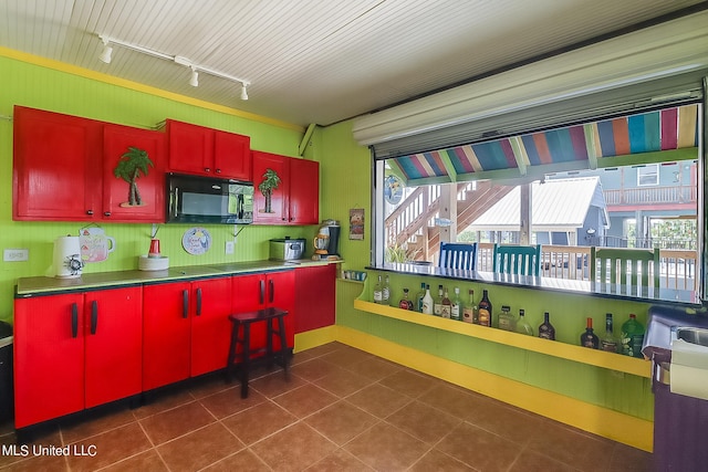 kitchen with dark tile patterned floors and track lighting