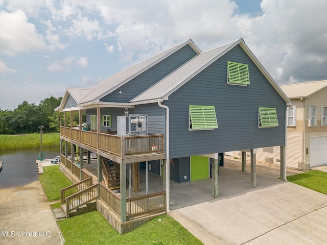 exterior space with a deck with water view, a yard, and a carport