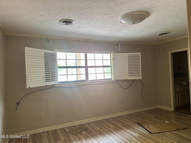 25 Oak Creek Pl, Jackson, MS 39211 - empty room featuring a textured ceiling, ornamental molding, and wood finished floors