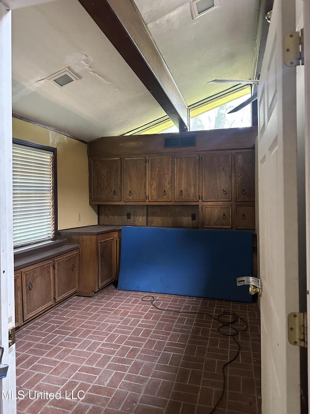 25 Oak Creek Pl, Jackson, MS 39211 - kitchen featuring brick floors, lofted ceiling, and dark countertops