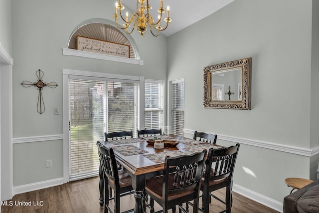 dining room featuring hardwood / wood-style flooring, high vaulted ceiling, and a chandelier