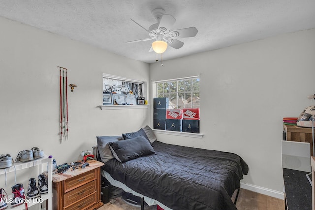 bedroom with ceiling fan, hardwood / wood-style flooring, and a textured ceiling