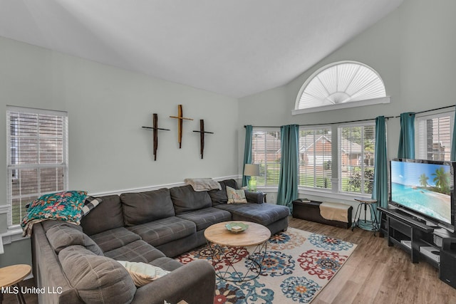 living room featuring light hardwood / wood-style flooring and high vaulted ceiling