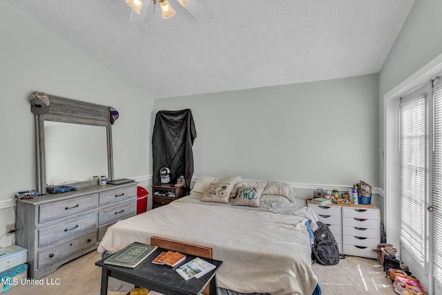 bedroom with lofted ceiling, a textured ceiling, light colored carpet, and ceiling fan