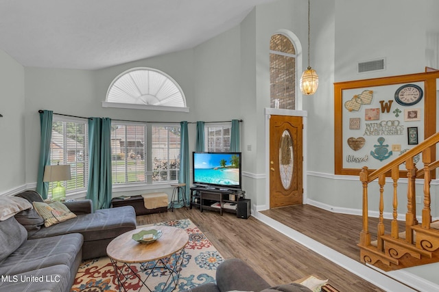 living room with high vaulted ceiling and wood-type flooring