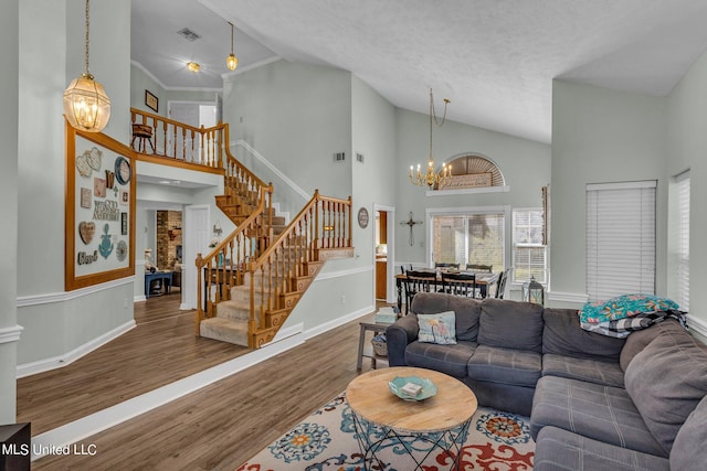 living room with a chandelier, a textured ceiling, dark hardwood / wood-style floors, and high vaulted ceiling