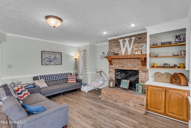 living room featuring crown molding, a textured ceiling, light hardwood / wood-style flooring, and a fireplace