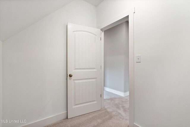 8025 Old Addison Dr, Olive Branch, MS 38654 - hallway featuring light carpet, lofted ceiling, and baseboards
