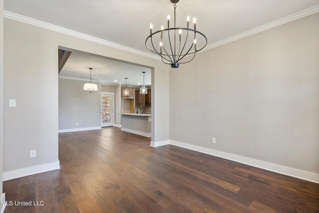 8025 Old Addison Dr, Olive Branch, MS 38654 - unfurnished living room with a chandelier, a sink, baseboards, dark wood-type flooring, and ornamental molding