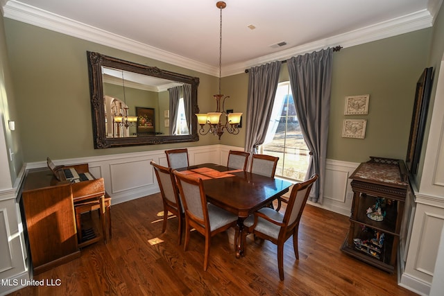 dining space featuring crown molding, dark hardwood / wood-style floors, and a chandelier