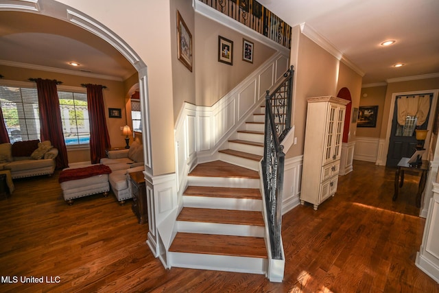 stairway with crown molding and wood-type flooring