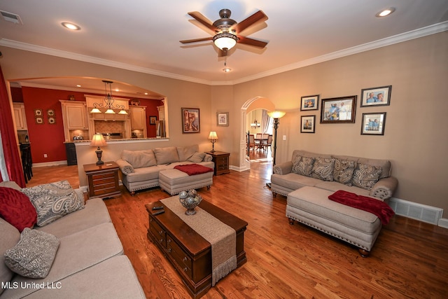 living room with hardwood / wood-style floors, ornamental molding, and ceiling fan