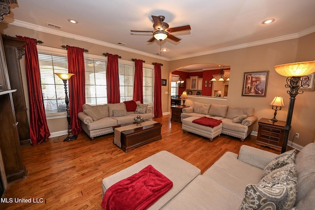 living room featuring ceiling fan, ornamental molding, and wood-type flooring