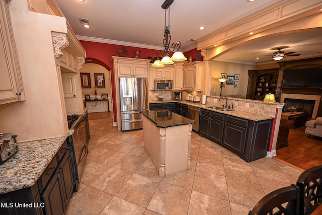 kitchen featuring a kitchen island, appliances with stainless steel finishes, pendant lighting, sink, and kitchen peninsula