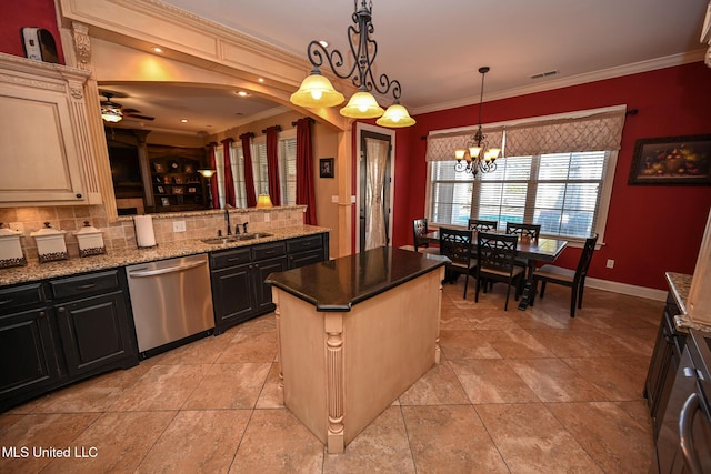 kitchen with sink, hanging light fixtures, dark stone countertops, dishwasher, and a kitchen island