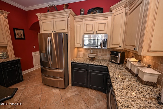 kitchen with light stone counters, ornamental molding, appliances with stainless steel finishes, and decorative backsplash