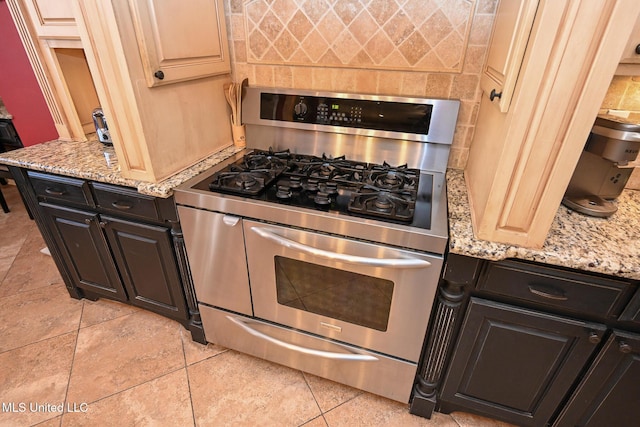 kitchen featuring light stone counters, light tile patterned flooring, and range with two ovens