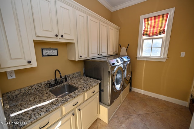 clothes washing area featuring light tile patterned flooring, separate washer and dryer, sink, cabinets, and ornamental molding