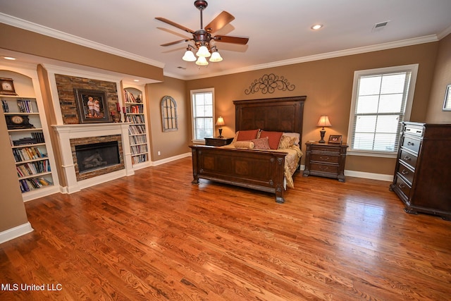 bedroom with crown molding, ceiling fan, a fireplace, and multiple windows