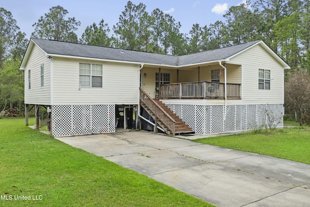 view of front facade featuring concrete driveway, a front yard, stairway, and a shingled roof
