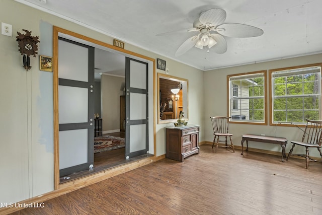 unfurnished room featuring ceiling fan, baseboards, ornamental molding, and wood finished floors