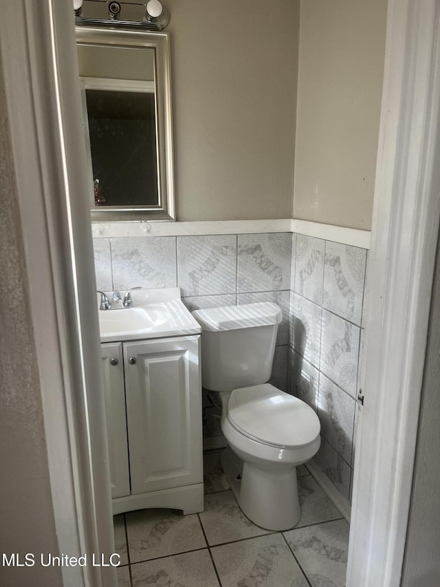 3006 Oak Forest Dr, Jackson, MS 39212 - bathroom with marble finish floor, tile walls, toilet, wainscoting, and vanity
