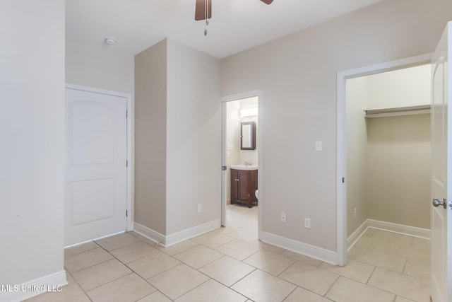200 Jeff Davis Ave Unit 8, Long Beach, MS 39560 - unfurnished bedroom with light tile patterned flooring, a spacious closet, a sink, connected bathroom, and baseboards