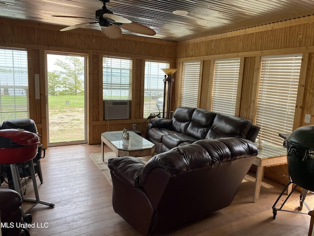 living room featuring light wood-type flooring, ceiling fan, and wood walls