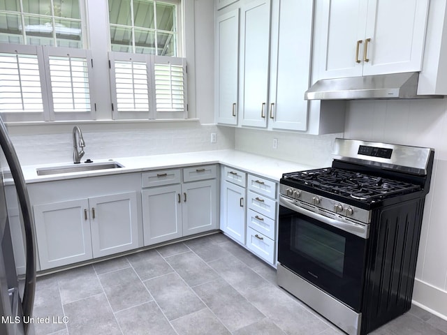902 Washington St, Natchez, MS 39120 - kitchen with stainless steel gas stove, exhaust hood, light countertops, and tasteful backsplash