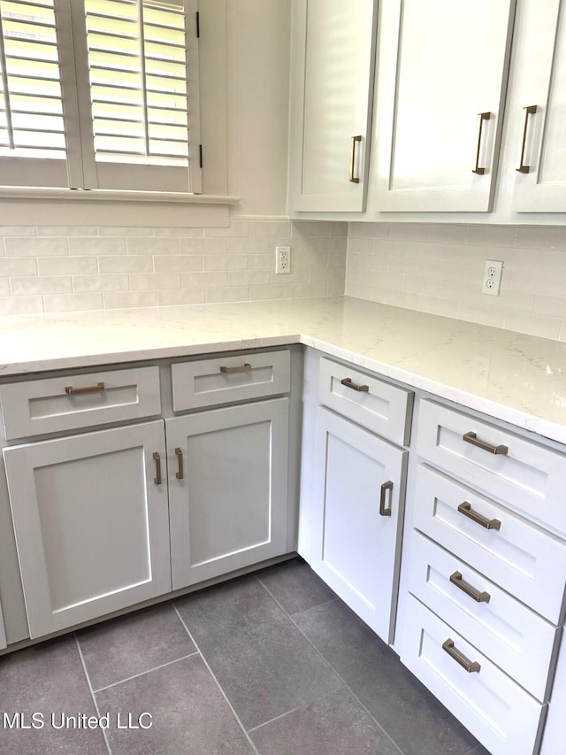 902 Washington St, Natchez, MS 39120 - kitchen featuring dark tile patterned flooring, decorative backsplash, and light stone countertops