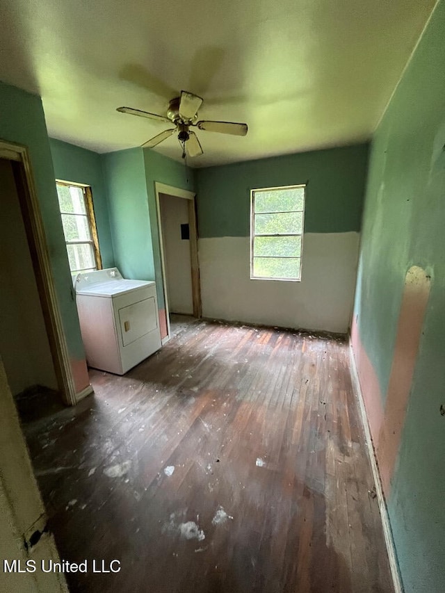 interior space featuring dark wood-type flooring, ceiling fan, washer / clothes dryer, and a wealth of natural light