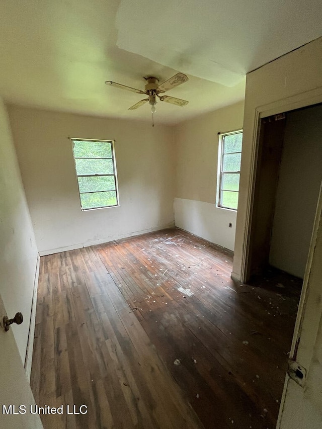 unfurnished bedroom with dark wood-type flooring, ceiling fan, and a closet