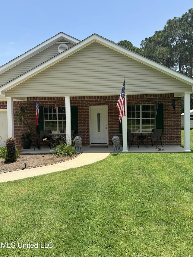 1720 Barracuda Dr, Gautier, MS 39553 - view of front facade featuring a front yard, brick siding, and a porch