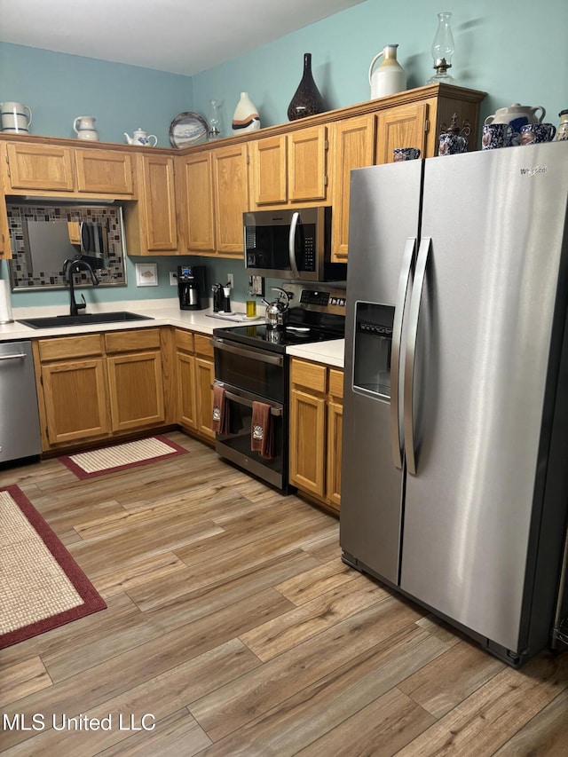 1720 Barracuda Dr, Gautier, MS 39553 - kitchen featuring appliances with stainless steel finishes, a sink, light countertops, and light wood finished floors