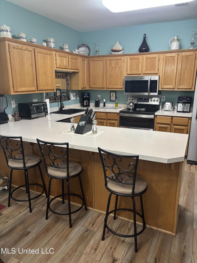 1720 Barracuda Dr, Gautier, MS 39553 - kitchen featuring electric range, stainless steel microwave, a sink, a peninsula, and light countertops