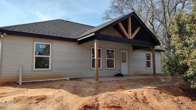 exterior space featuring roof with shingles and a patio area