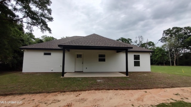 109 N Barnett St, Poplarville, MS 39470 - rear view of house with roof with shingles, a patio area, and a lawn