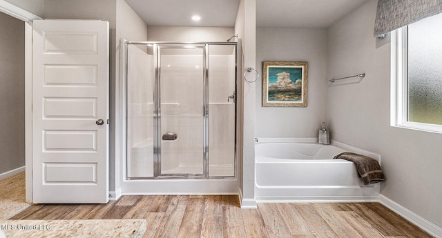 bathroom with hardwood / wood-style floors and separate shower and tub