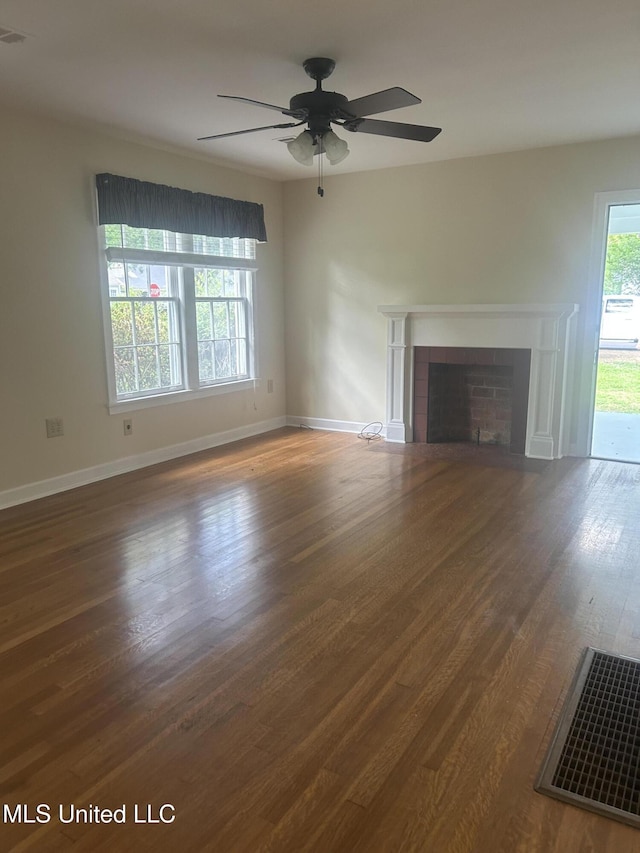 501 W Jefferson Ave, Greenwood, MS 38930 - unfurnished living room featuring visible vents, a ceiling fan, wood finished floors, and a fireplace