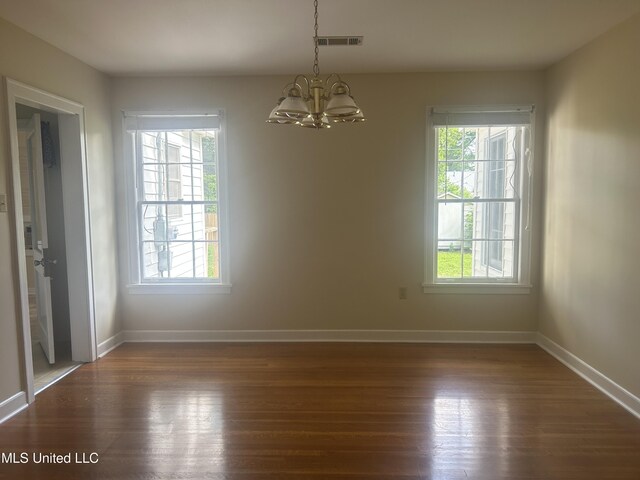 501 W Jefferson Ave, Greenwood, MS 38930 - unfurnished dining area featuring visible vents, dark wood finished floors, baseboards, and a chandelier