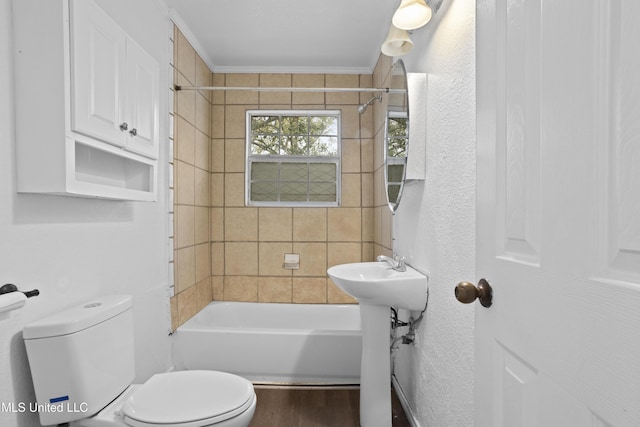 full bathroom featuring tiled shower / bath, wood-type flooring, sink, toilet, and crown molding