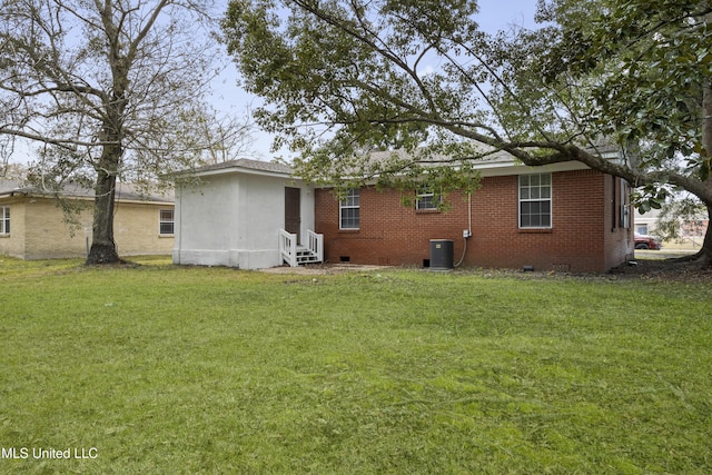 back of property with a yard and central air condition unit